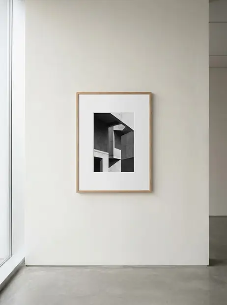 Visuel d'ambiance : une œuvre encadrée seule sur un grand mur blanc, un banc de bois clair au premier plan